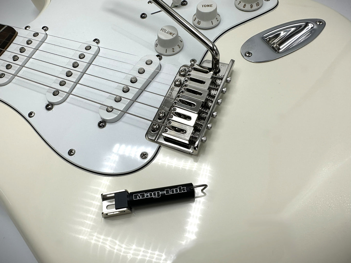 White electric guitar with a Black Lock lock attached to it