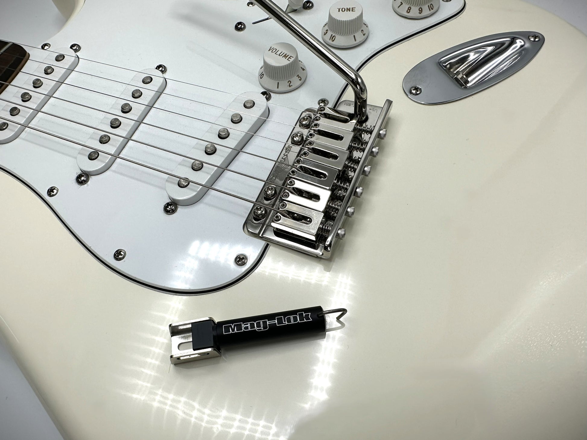 White electric guitar with a Black Lock lock attached to it